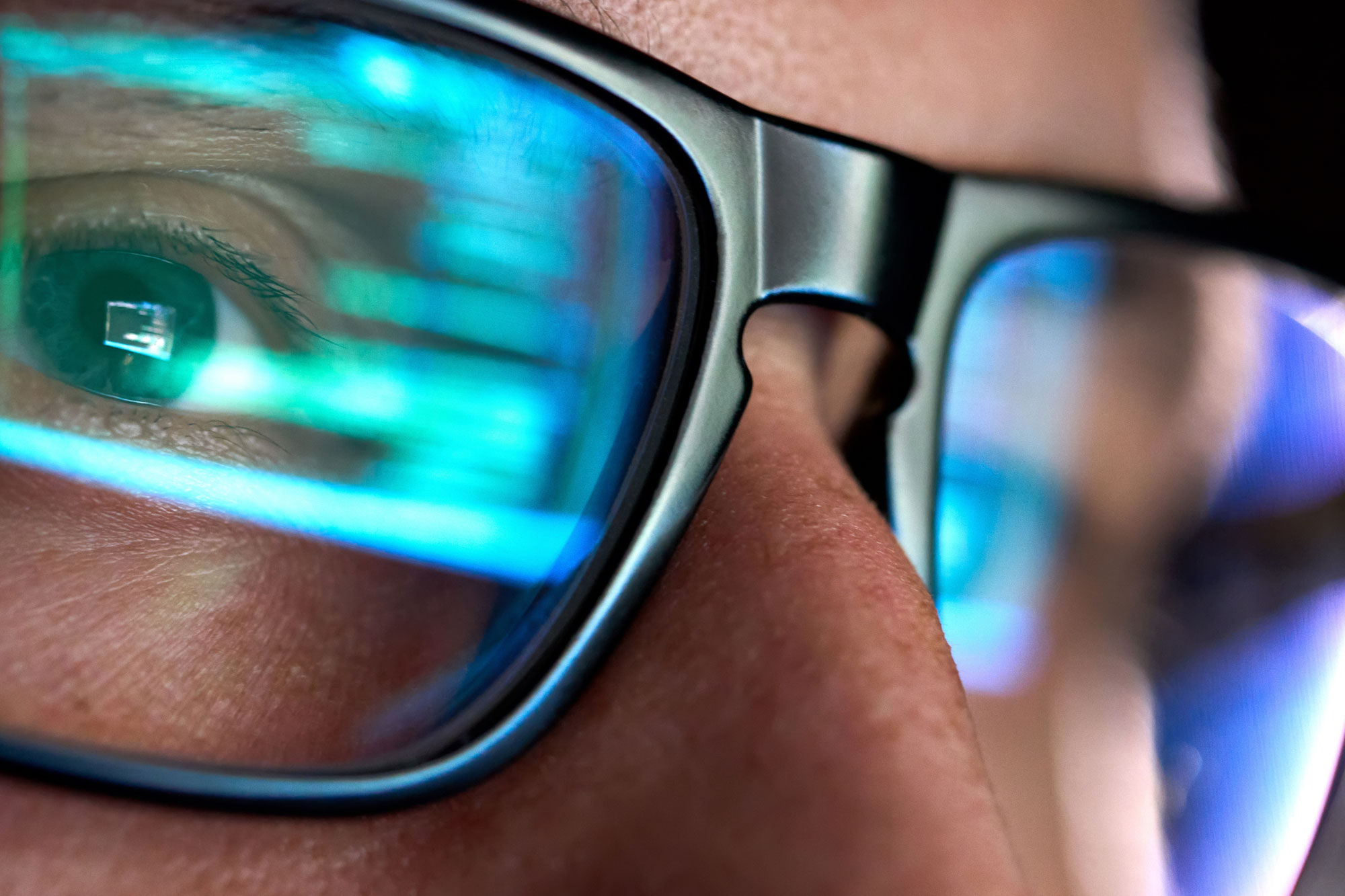 A man with glasses looking at a computer and reading about NetSuite consulting